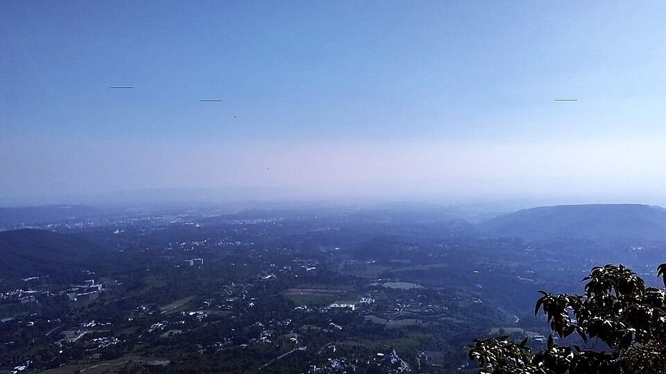 Wide aerial panorama of Dehradun city surrounded by Shivalik Hills — ideal location for drone photography in Uttarakhand